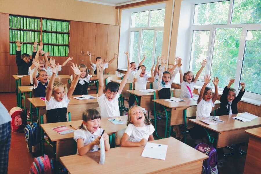 primary school with happy kids at their clean desks, germ protection Nanoman antibacterial